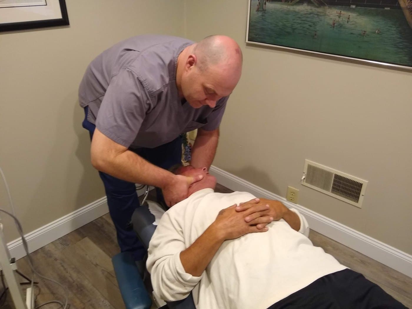 Dr. David DeFries providing hands-on neck care during a house call