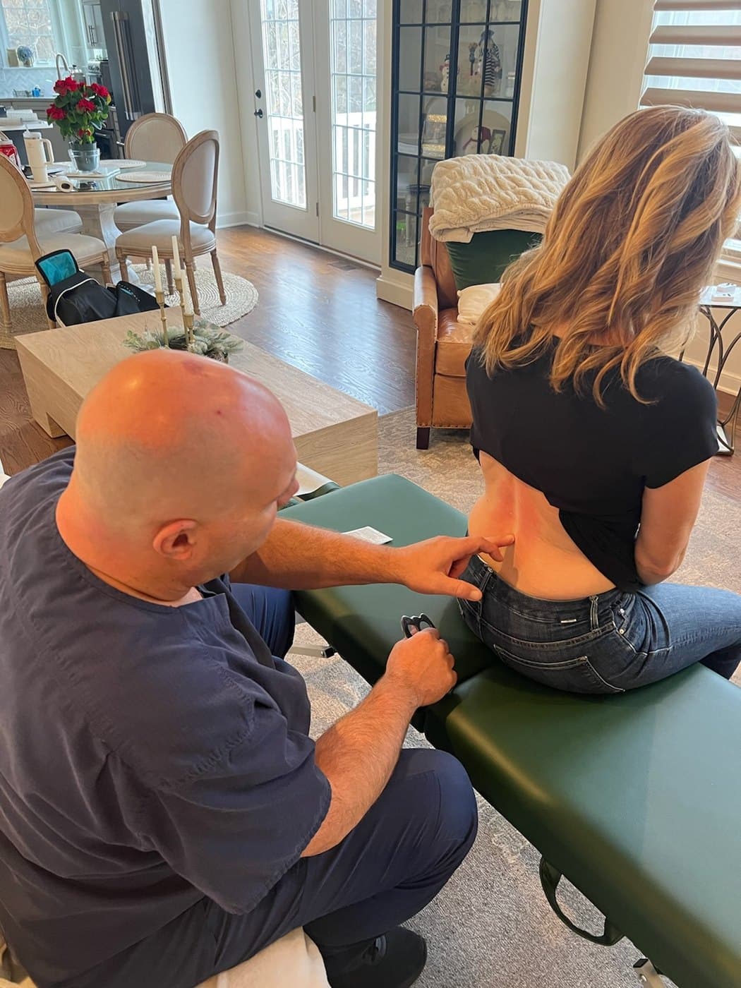 Dr. David DeFries providing instrument-assisted soft tissue care around the upper back